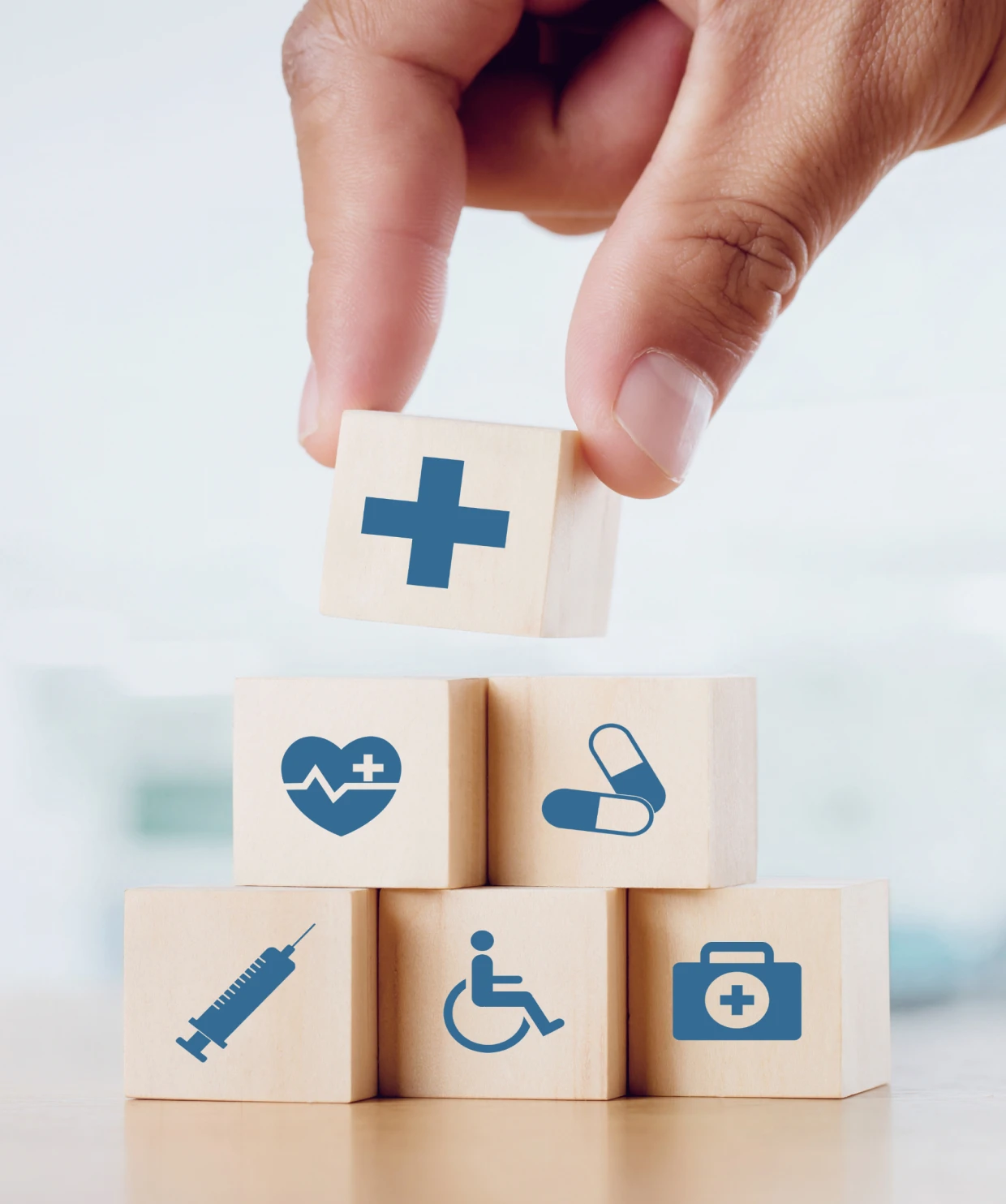 Hand stacking wooden blocks with medical icons